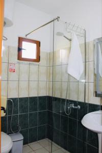 a bathroom with a shower with a toilet and a sink at ANORA Mare Suites in Orikum +31 photos
