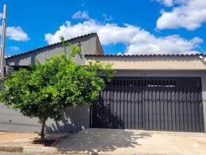 a black garage door with a tree in front of it at Studio Moderno e Prático Wi-Fi Rápido e AC in Ribeirão Preto