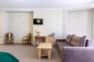 a living room with a couch and a table at Elit Garden Hotel in Kamianets-Podilskyi