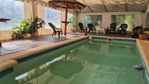a swimming pool with chairs and a table and an umbrella at Los Abuelos in Potrero de Garay +21 photos