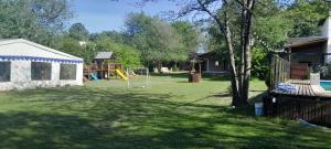 a large yard with a playground and a tree at Los Abuelos in Potrero de Garay