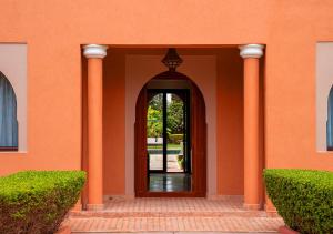 an orange building with an entry way with a door at Luxury villa in Azib Oulad Lâdem +26 photos