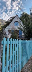 a blue picket fence in front of a house at La maison bleue des Pyrénées in Argut-Dessous