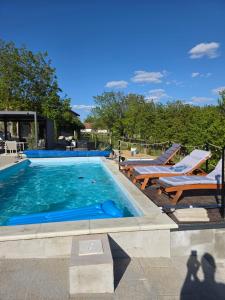 a swimming pool with two lounge chairs and a swimming pool at The Dream house in Tomaš