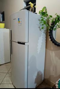 a white refrigerator in a kitchen with a plant at Chacara castanheira in Ariquemes