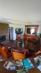 a living room with leather furniture and a fireplace at Casa Do Olival in São João da Pesqueira