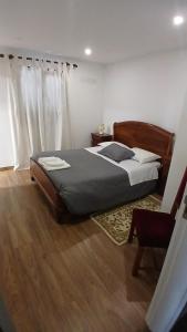 a bedroom with a bed and a chair at Casa Do Olival in São João da Pesqueira