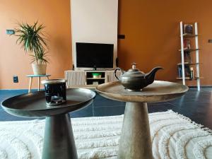a living room with two tables with a tea pot on them at Aux 1001 Nuits Marrakech's touch in Chapelle-lez-Herlaimont