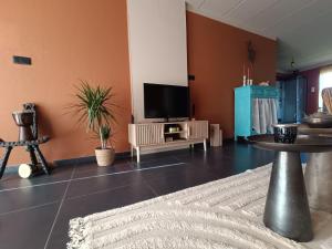 a living room with a tv and a table at Aux 1001 Nuits Marrakech's touch in Chapelle-lez-Herlaimont