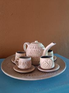 a plate with three cups and a tea pot on it at Aux 1001 Nuits Marrakech's touch in Chapelle-lez-Herlaimont +20 photos