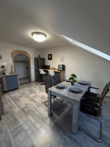 a living room with a table and a kitchen at Casa Antic Große Moderne 45qm wohnung im Zentrum Am Bahnhof Kostenloses WLAN in Saalfeld