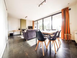 ein Wohnzimmer mit Tisch, Stühlen und Sofa in der Unterkunft Castelgolf in Barvaux