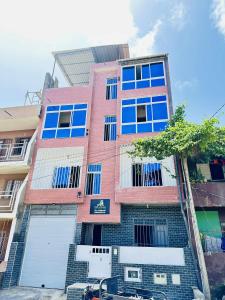 a tall brick building with blue windows and a garage at Apartamento em Pedra Badejo in Pedra Badejo