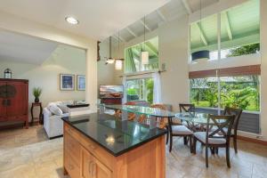 a kitchen and living room with a table and chairs at Puamana 19C in Princeville