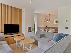 a living room with a couch and a tv at Het Duinnest in Kamperland