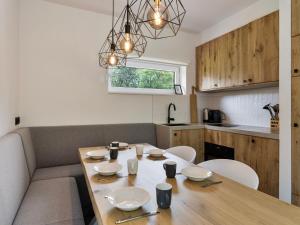 a dining room with a table and chairs and a kitchen at Het Duinnest in Kamperland