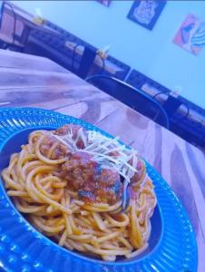 a blue plate of pasta with meat and sauce at Pousada Quixadá Confort in Quixadá