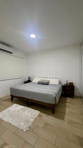 a bedroom with a bed and a white wall at Casa Costa Hermosa in Tijuana