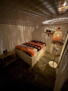 a small bedroom with a bed and a lamp at Isla fuerte House in Puerto Limón