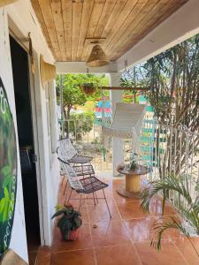 a patio with chairs and a hammock on a porch at Isla fuerte House in Puerto Limón