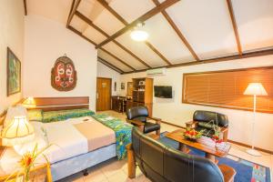 a bedroom with a bed and a table and chairs at Madang Resort in Madang