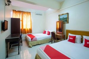 a hotel room with two beds and a desk at perfect class hotel in Kuala Lumpur