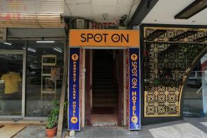 a sign that says spot on in front of a building at perfect class hotel in Kuala Lumpur
