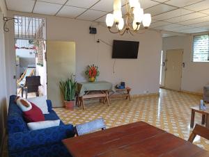 a living room with a blue couch and a tv at Mountain View Hostel in Santa Ana
