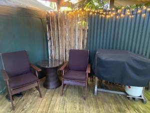 two purple chairs and a table in a tent at Nikau Sanctuary in Raglan