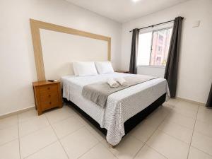 a bedroom with a bed with two towels on it at Apartamento perto do aeroporto e do estádio do mangueirão in Belém +22 photos