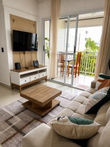 a living room with a couch and a flat screen tv at Apartamento perto do aeroporto e do estádio do mangueirão in Belém