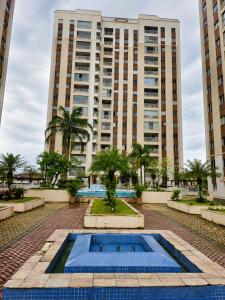 a swimming pool in front of a tall building at Apartamento perto do aeroporto e do estádio do mangueirão in Belém