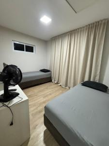 a bedroom with a bed and a fan on a table at Kitnet bem equipada para 2 pessoas in Curitiba