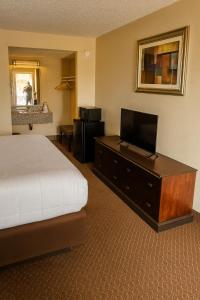 a hotel room with a bed and a flat screen tv at MHO Hotel Eloy Casa Grande Near I-10 in Eloy