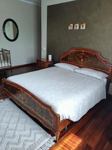 a bedroom with a large bed with a wooden frame at Casa Vicino in Carrù