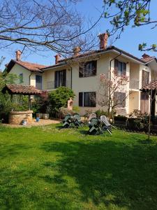 a large house with chairs in the yard at Casa Vicino in Carrù