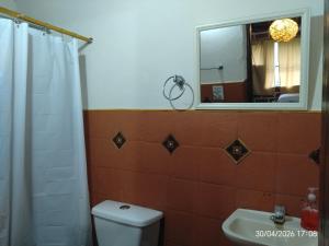 a bathroom with a toilet and a sink and a mirror at Casa Campestre Familiar in Medellín