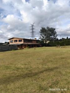 a building with a field in front of it at Casa Campestre Familiar in Medellín