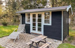 a black house with a picnic table and two chairs at Stunning Home In Højslev With Wifi in Højslev
