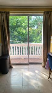 a room with a large window with a view of a balcony at Comfort Suites - Studio Two in La Fargue