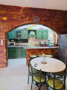 a kitchen with green cabinets and a table with chairs at casabianca north coast chalet code 20 in Borg El Arab