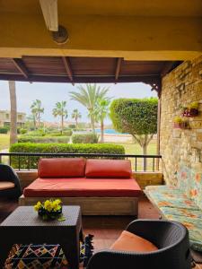 a living room with a red couch on a patio at casabianca north coast chalet code 20 in Borg El Arab