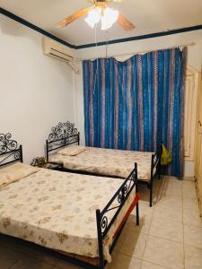 a bedroom with two beds and a ceiling fan at casabianca north coast chalet code 20 in Borg El Arab