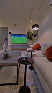 a living room with a couch and a flat screen tv at شقة سُبات الفندقية الفاخرة in Buraydah