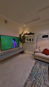 a living room with a flat screen tv on a wall at شقة سُبات الفندقية الفاخرة in Buraydah +2 photos