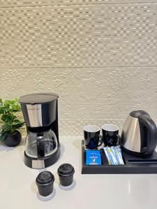 a coffee maker and two cups on a tray at شقة سُبات الفندقية الفاخرة in Buraydah