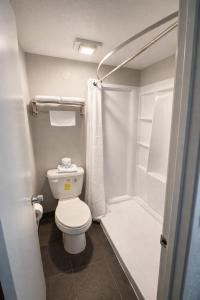 a small bathroom with a toilet and a shower at MHO Hotel Eloy Casa Grande Near I-10 in Eloy +23 photos