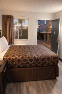 a large bed in a hotel room with a window at MHO Hotel Eloy Casa Grande Near I-10 in Eloy