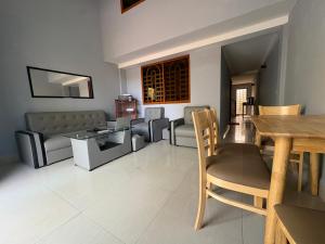 a living room with a couch and a table and chairs at Wheelezz in Kep +41 photos