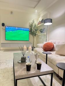 a living room with a couch and a tv at شقة سُبات الفندقية الفاخرة in Buraydah